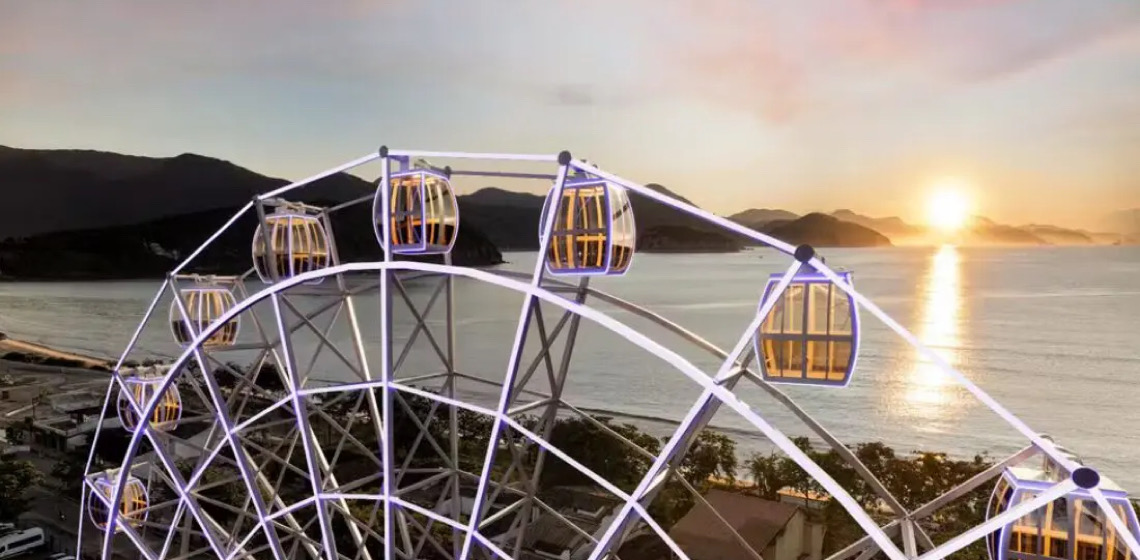 Se você busca uma experiência que combine diversão, emoção e vistas inesquecíveis, a Roda-Gigante de Ubatuba é parada obrigatória. Localizada no Ubatuba Mall, no bairro Itaguá, essa atração já se tornou um novo cartão-postal da cidade. Ela oferece uma perspectiva única do litoral paulista. Com 38 metros de altura, 22 cabines climatizadas e tecnologia de ponta, a roda-gigante proporciona momentos especiais para todas as idades. A cada giro, os visitantes contemplam paisagens de tirar o fôlego: o mar cristalino, a Serra do Mar e a Mata Atlântica preservada formam um verdadeiro espetáculo natural. Um passeio que une emoção e conforto A Roda-Gigante de Ubatuba oferece conforto e segurança em todas as cabines climatizadas. Além disso, a tecnologia bluetooth permite que os visitantes toquem suas playlists durante o passeio, tornando a experiência ainda mais divertida e memorável. À noite, a roda se transforma em um show de cores com 19 mil LEDs, iluminando Itaguá e encantando todos os visitantes. Esse espetáculo combina emoção, contemplação e entretenimento em um único passeio. Localização estratégica e turismo O bairro Itaguá é um dos pontos mais vibrantes de Ubatuba. Além de estar no Ubatuba Mall, que reúne comércio, restaurantes e serviços turísticos, a roda-gigante fica próxima a praias e trilhas. Assim, ela se torna parte de um roteiro turístico completo, unindo lazer urbano e contato direto com a natureza. Por que visitar a Roda-Gigante de Ubatuba O passeio oferece vistas panorâmicas do litoral, da cidade e da Serra do Mar. Todas as idades podem aproveitar a experiência, incluindo crianças, adultos e até pets. Durante a noite, o LED show transforma a atração em um espetáculo imperdível. Além disso, a localização central e a infraestrutura completa tornam a visita ainda mais prática e agradável. Portanto, a Roda-Gigante é mais do que um passeio: é uma experiência turística completa que combina emoção, contemplação e diversão. Para quem deseja explorar ainda mais Ubatuba e descobrir outras experiências incríveis, não deixe de conferir nosso artigo sobre trilhas, cachoeiras e natureza preservada em Ubatuba. Assim, você consegue planejar um roteiro completo de lazer, turismo e contato com a natureza.